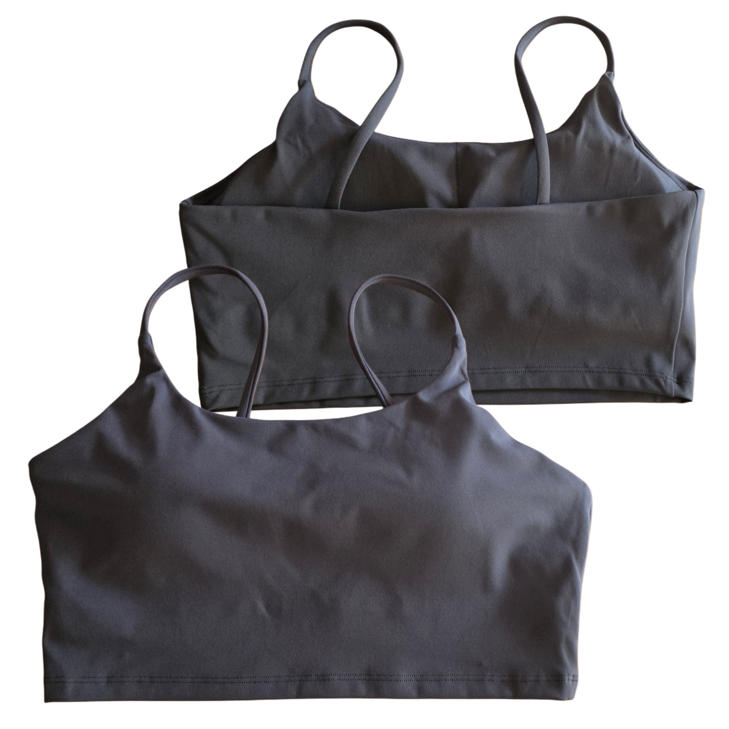 Two black crop tops with thin straps on a white background