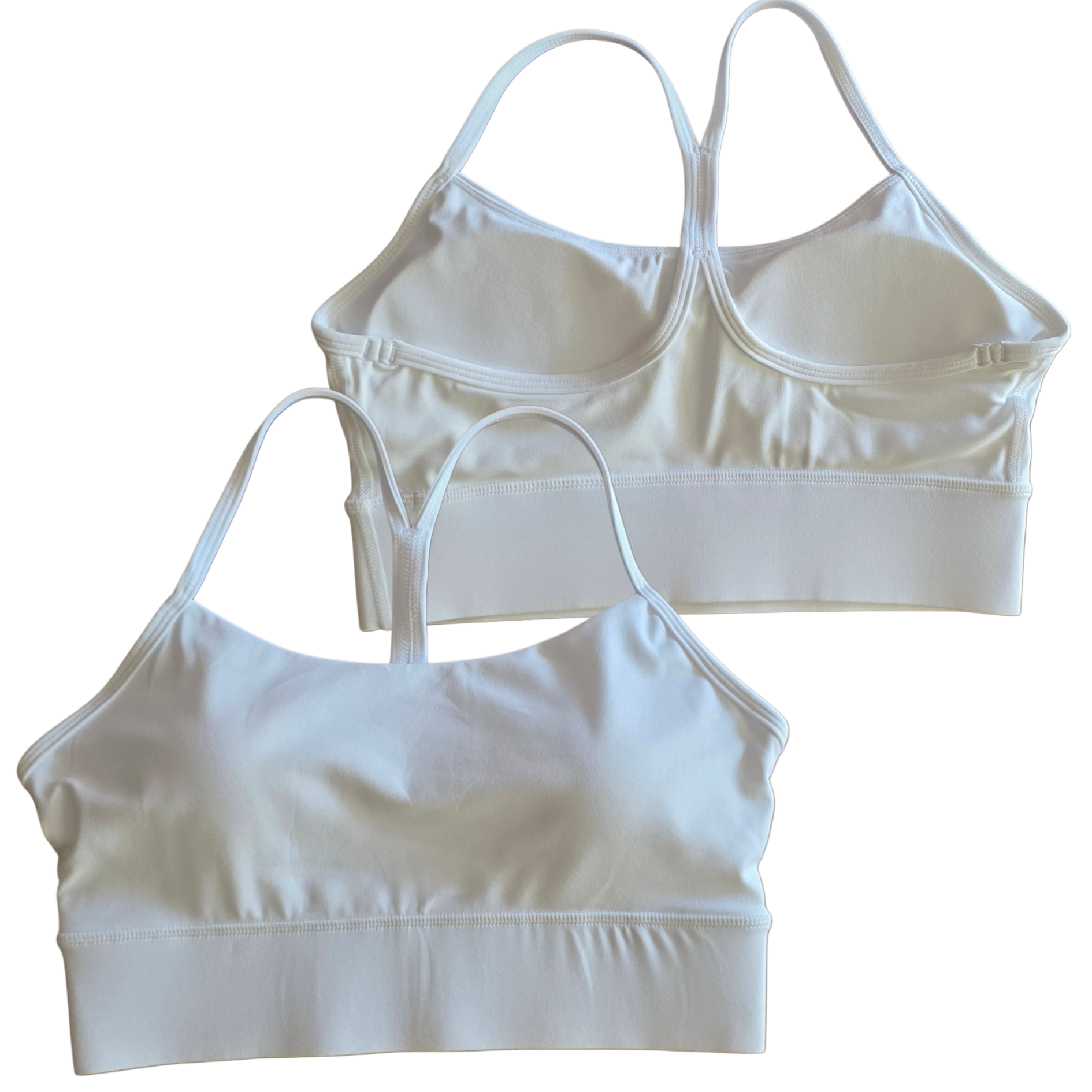 Two white sports bras on a white background