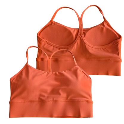 Two orange sports bras on a white background