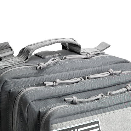 Close-up of a gray tactical bag with zippers and straps on a white background