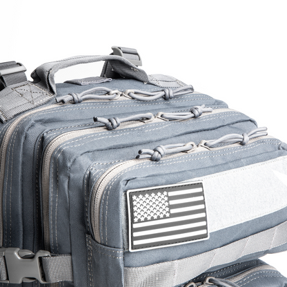Gray tactical backpack with American flag patch on a white background
